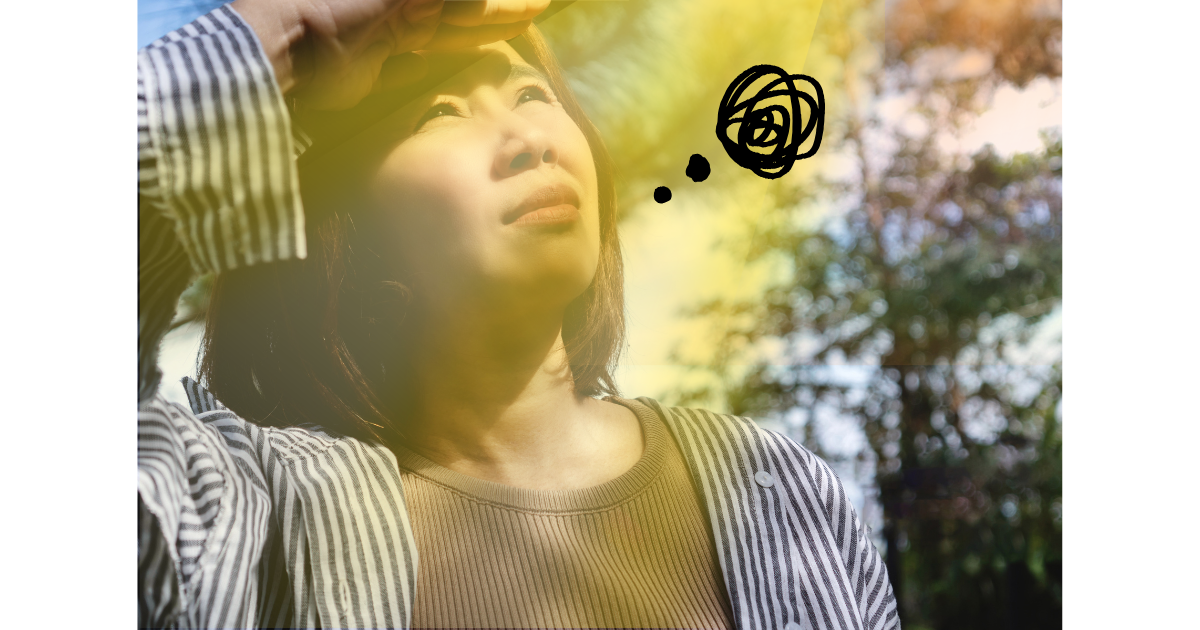 紫外線を眩しそうに見上げる女性。髪と頭皮も紫外線を浴びていることに気づくイメージ
