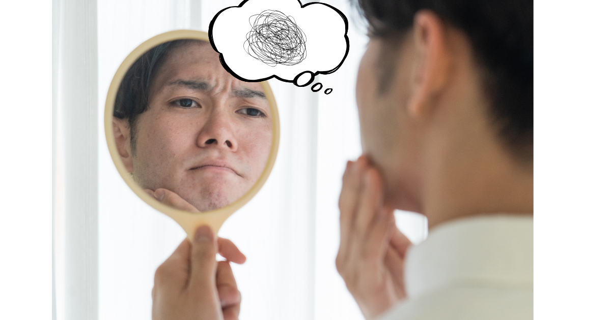 鏡でヒゲ剃り後の肌を気にする男性